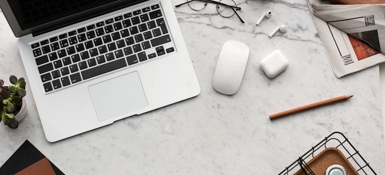 a laptop on the table next to glasses and a pencil