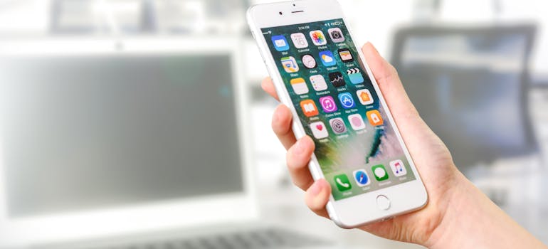a hand holding phone with social media apps