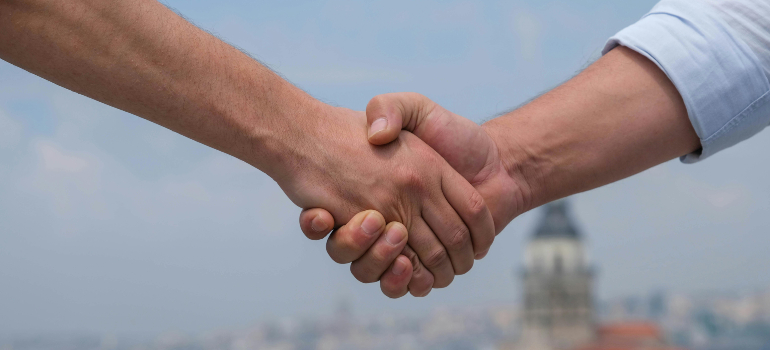 Two hands shaking representing the need for patient-centric marketing in addiction.