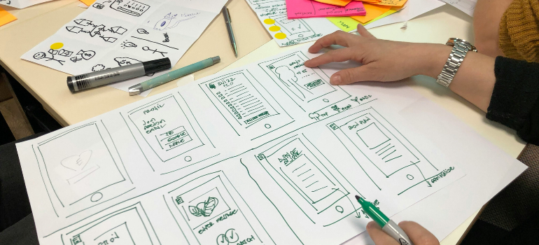 A workshop table with sketches for marketing holistic approaches in drug addiction treatment.
