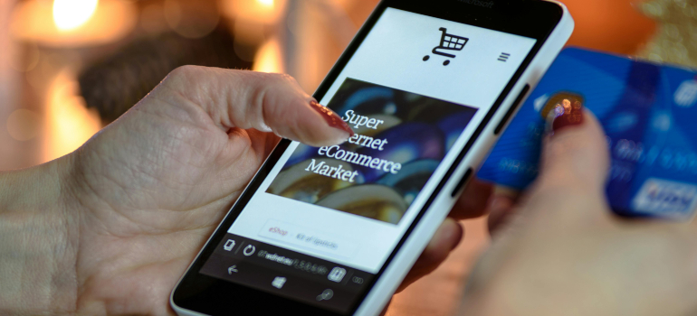 Close-up of a person using a smartphone and holding a credit card, focusing on optimizing your E-Commerce site for conversions.