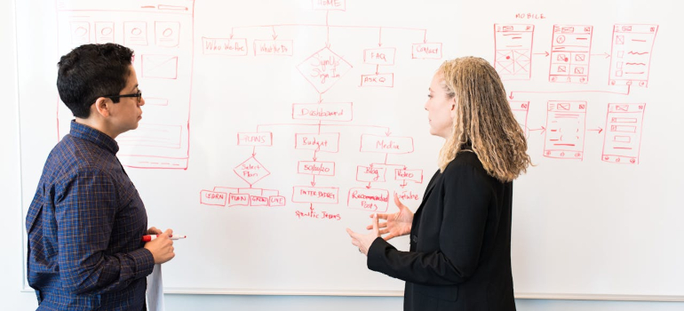 two people looking at stats on a whiteboard