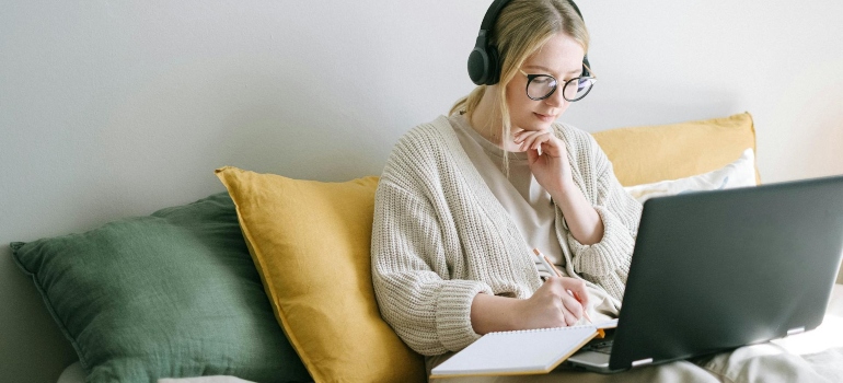a girl with headphones doing something on her laptop