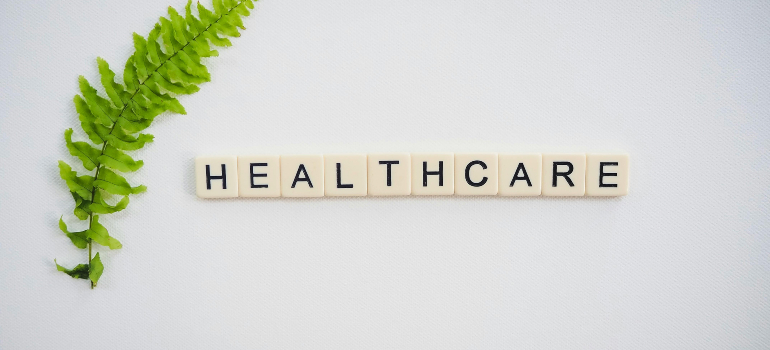 Scrabble tiles spelling 'healthcare' with a green leaf.