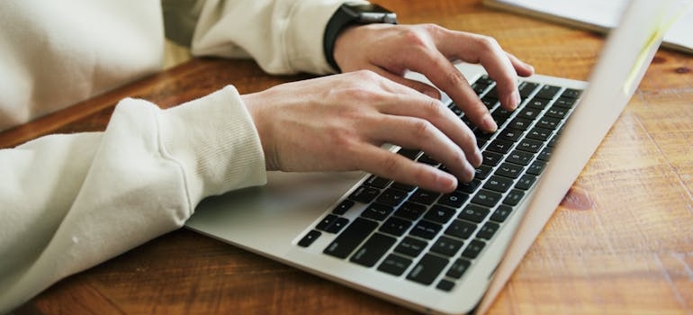 A person typing on a laptop keyboard
