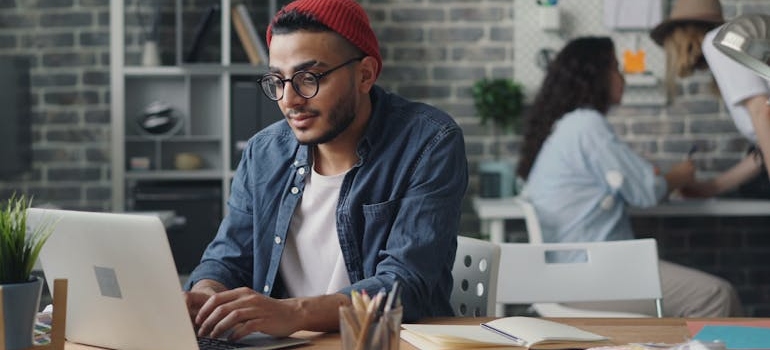 A person using a laptop to write about how blogging helps mental health practices rank higher