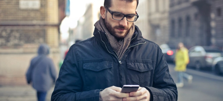 a man walking on the street and looking at his phone