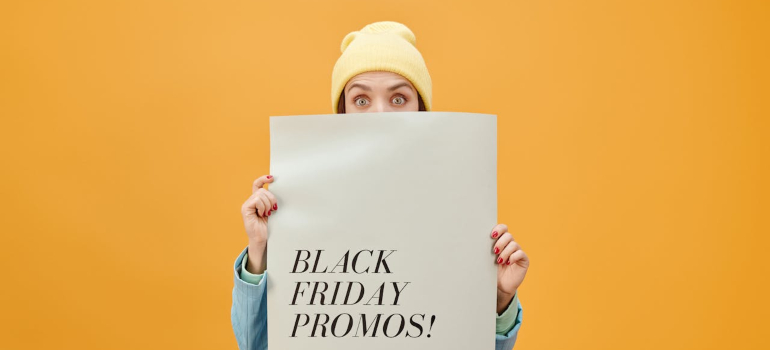 A woman holding a sign that says black friday promos