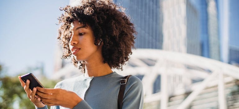 A person outdoors using their smartphone to book an appointment at an aesthetic clinic
