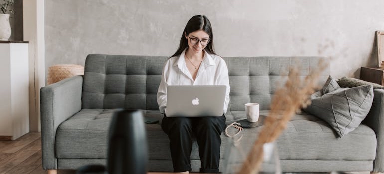 A person sitting on the couch and reading emails from a rehab center
