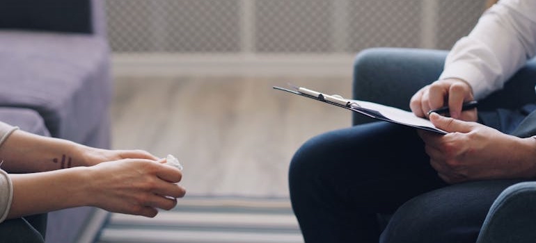 A therapist taking notes while talking to a person