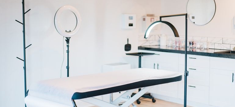 Modern aesthetic treatment room with equipment and treatment bed