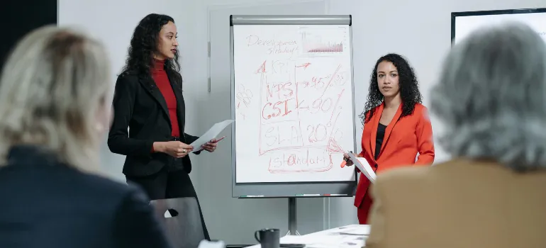 Women presenting reviewing performance of their counseling private practice business plan